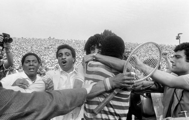 Le Français Yannick Noah embrasse son père camerounais Zaccharie,  le 5 juin 1983, sur le cour central de Roland-Garros à Paris après avoir remporté les 23e Internationaux de France [Dominique Faget / AFP/Archives]