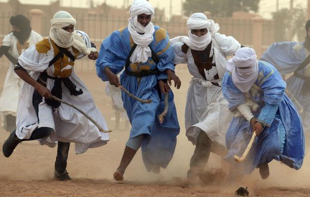 Des hommes jouent au "hockey nomade" dans le désert marocain, le 16 mars 2013 [Fadel Senna / AFP]