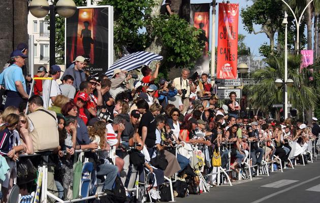 Des spectateurs attendent devant le Palais du Festival, le 21 mai 2006 à Cannes [Pascal Guyot / AFP/Archives]