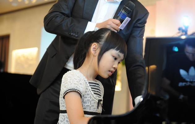 Le pianiste Lang Lang regarde le travail d'une jeune pianiste lors d'une masterclass organisée en août 2011 à Hong Kong [Joyce Woo / AFP/Archives]