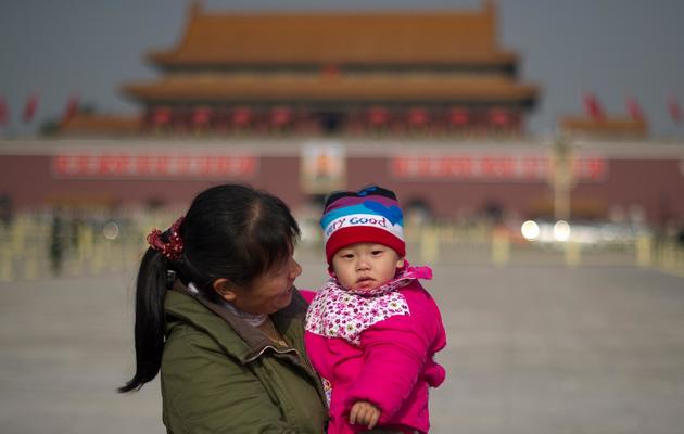 Une femme et son enfant place Tiananmen, le 9 novembre 2012 à Pékin [Ed Jones / AFP]