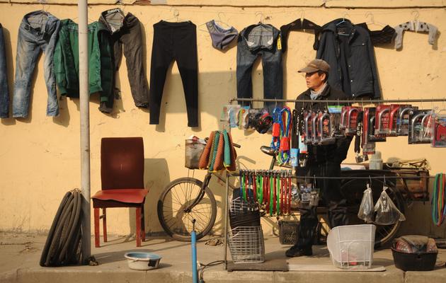 Un réparateur de bicyclette attend les clients, le 10 janvier 2013 à Pékin [Peter Parks / AFP/Archives]