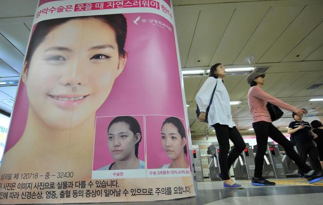 Une affiche pour vanter les opérations esthétiques, le 22 mai 2013, dans le métro de Séoul [Jung Yeon-Je / AFP]