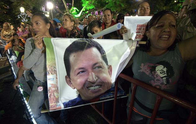 Des supporteurs de Hugo Chavez brandissent son portrait, le 11 décembre 2012 à Caracas [Juan Barreto / AFP]