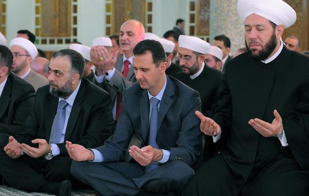 Photo de l'agence officielle syrienne montrant le président Bachar al-Assad (c) en train de prier lors de l'Aïd, en août 2011 à Damas [ / Sana/AFP/Archives]