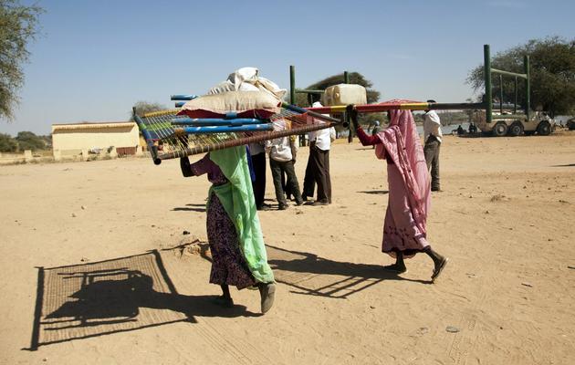 Photo fournie par la Mission des Nations Unies au Darfour (UNAMID) de femmes déplacées portant leurs effets personnels à El Sireaf dans le nord du Darfour, le 14 janvier 2013 [Sojoud el-Garrai / UNAMID/AFP/Archives]