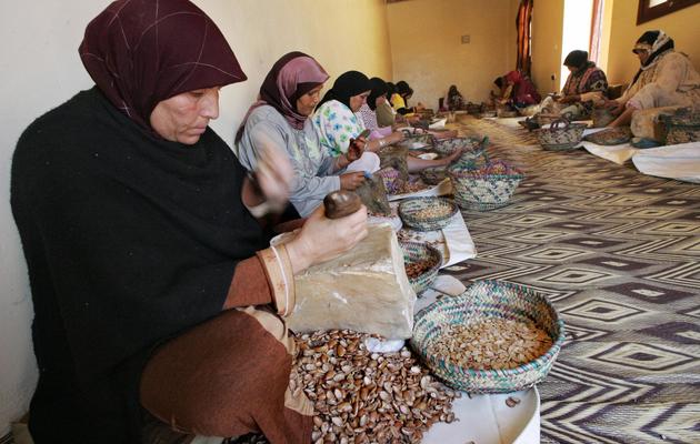 Des Marocaines écrasent des noix d'arganier, à Smimmou, dans le nord ouest du pays [Abdelhak Senna / AFP/Archives]