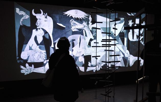 Une personne regarde, le 5 janvier 2009 au Musée Granet à Aix-en-Provence, une projection interactive du célèbre tableau de Pablo Picasso "Guernica" [Gerard Julien / AFP/Archives]