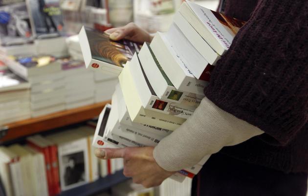 Un eployé d'une librairie porte des livres [Francois Guillot / AFP/Archives]