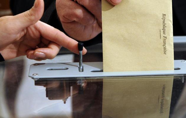 Une personne insère son bulletin de vote dans l'urne, dans un bureau de Nantes, lors des législatives le 17 juin 2012 [Jean-Christophe Verhaegen / AFP/Archives]