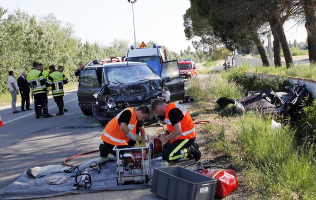 Des pompiers portent secours aux passagers d'un véhicule sur une route entre Arles et Les Saintes-Maries-de-la-Mer, le 17 juin 2012 [ / AFP/Archives]