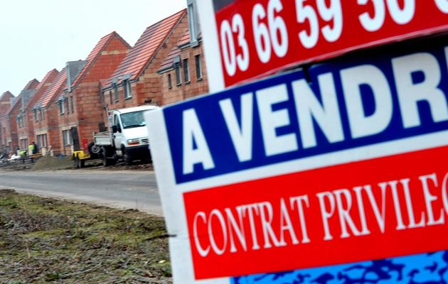 Un panneau d'un promoteur immobilier annonçant la mise en vente de maisons individuelles neuves, devant un chantier [Philippe Huguen / AFP/Archives]