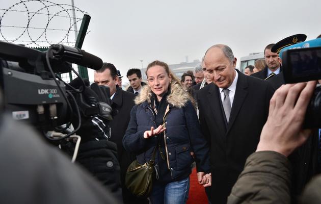 Florence Cassez accompagnée de Laurent Fabius, ministre des Affaires étrangères, lors de son arrivée à l'aéroport de Roissy, le 24 janvier 2013 [Bertrand Langlois / AFP]