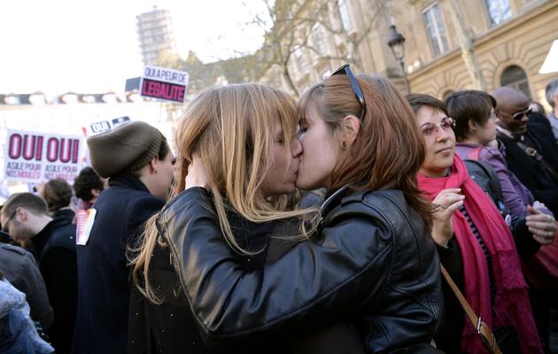 Deux femmes s'embrassent devant la mairie de Paris, le 23 avril 2013, après l'adoption par l'Assemblée nationale de la loi sur le mariage gay [Bertrand Guay / AFP/Archives]