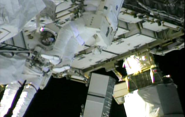 Sur cette photo fournie par Nasa TV le 11 mai 2013, les deux astronautes Chris Cassidy (g) et Tom Marshburn tentent de réparer l'ISS [ / Nasa TV/AFP]