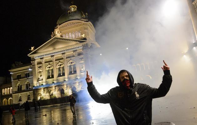 Un manifestant au milieu des gaz lacrymogènes lors des affrontements devant le Parlement Fédéral à Berne, le 25 mai 2013 [Fabrice Coffrini / AFP]