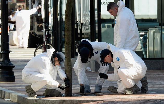 Des enquêteurs sur le lieu de l'attentat du marathon de Boston cherchent encore des indices, le 21 avril 2013 [Kevork Djansezian / Getty Images/AFP]