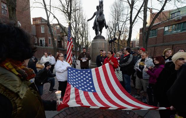 Des personnes tiennent un drapeau américain lors d'une cérémonie à Boston en mémoire aux victimes de l'attentat, le 21 avril 2013 [Kevork Djansezian / Getty Images/AFP]
