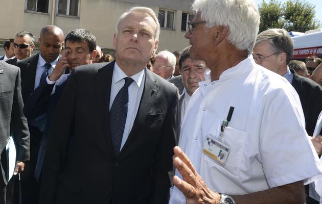 Le Premier ministre Jean-Marc Ayrault et le chef des urgences de l'hôpital de la Conception à Marseille, Marc Alazia, le 20 août 2013 [Boris Horvat / AFP/Archives]