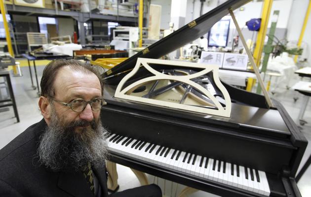 Le designer italien Michel de Lucchi pose le 3 décembre 2010 en face d'un piano qu'il a dessiné pour Pleyel [Francois Guillot / AFP/Archives]