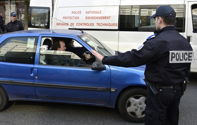 Un policier français arrête une voiture à Lyon le 14 mars 2014 pour vérifier son pot d'échappement [Philippe Desmazes / AFP]