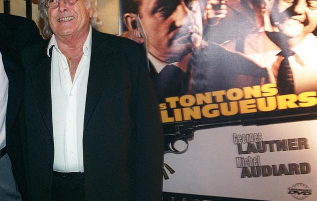 Le réalisateur des "Tontons flingueurs" Georges Lautner pose devant l'affiche du film, le 12 septembre 2002 au cinéma Max Linder à Paris [Frederick Florin / AFP/Archives]