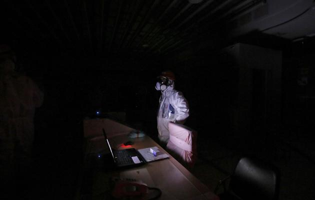 Un employé de Tepco lors d'une simulation de plongée dans le noir de la salle de contrôle des unités 1 et 2 de la centrale atomique Fukushima Daiichi, le 10 mars 2014 [Toru Hanai / Pool/AFP]