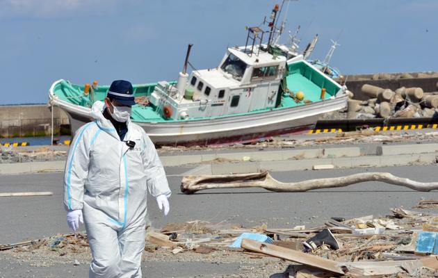 Un officier de police à la recherche de personnes disparues le 11 mars 2013 près de l'usine TEPCO à Fukushima  [Yoshikazu Tsuno / AFP/Archives]