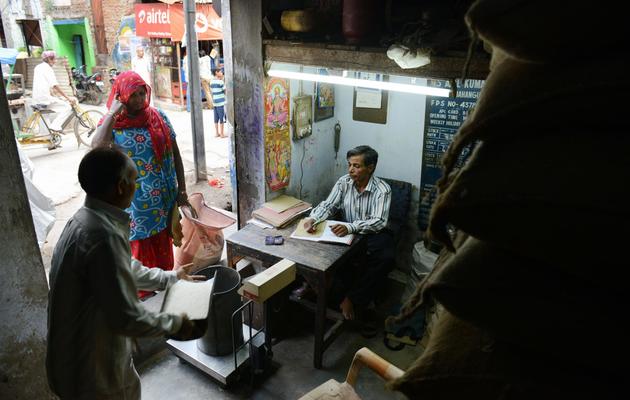 Le magasinier indien Brij Kishore (d) reçoit un client dans un dispensaire gouvernemental à Delhi le 10 juillet 2013 [Roberto Schmidt / AFP/Archives]