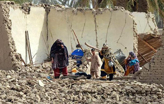 Photo fournie par le réseau d'information en ligne Oinn montrant des habitants au milieu des décombres après un violent séisme à Awaran, le 25 septembre 2013 au Pakistan [Oinn / Oinn/AFP]