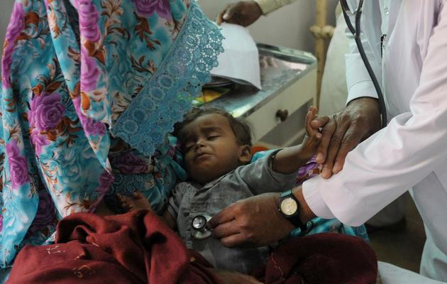 Un médecin pakistanais examine un enfant souffrant de malnutrition grave à la clinique de Mithi dans le désert du Thar au Pakistan, le 11 mars 2014 [Rizwan Tabassum / AFP]