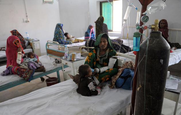 Les familles d'enfants victimes de famine s'occupent de leurs enfants dans la clinique de Mithi, située dans le désert du Thar au Pakistan, le 11 mars 2014 [Rizwan Tabassum / AFP]