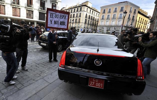Un homme tient une pancarte "Les Etats-Unis nous espionnent et nous volent" devant la voiture de l'ambassadeur américain en Espagne James Costos, le 28 octobre 2013 à Madrid [Gérard Julien / AFP]
