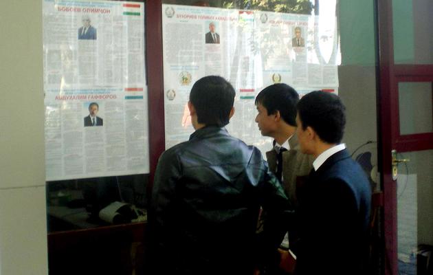 Des personnes lisent des affiches électorales, le 2 novembre 2013 à Douchanbé, avant la présidentielle au Tadjikistan [ / AFP]
