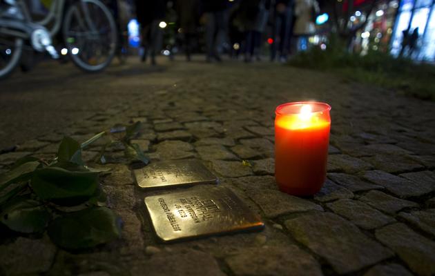 Une bougie et une rose déposées durant une marche commémorant le 75e anniversaire du pogrom lors de la "Nuit de cristal", le 9 novembre 2013 à Berlin  [ / AFP]