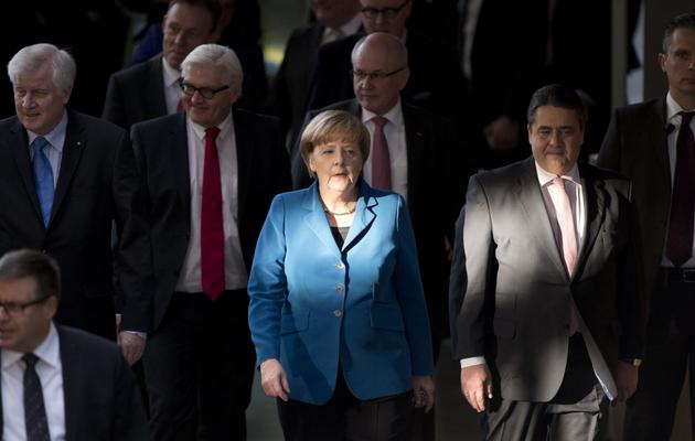 Angela Merkel (c) entourée de Horst Seehofer (g), Frank-Walter Steinmeier (2e g) et Sigmar Gabriel (2e d) le 16 décembre à Berlin avant la signature de l'accord de coalition entre le SPD et la CSU [John MacDougall / AFP]