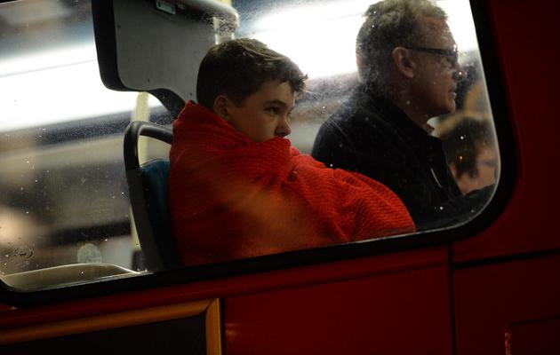 Des personnes blessées assises dans un bus après l'effondrement du toit du théâtre à Londres le 19 décembre 2013 [Leon Neal / AFP]