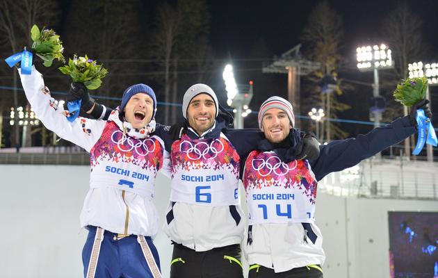 Le Français Martin Fourcade sur la plus haute marche du podium de poursuite du biathlon, entouré par son compatriote Jean-Guillaume Béatrix (D) et le tchèque Ondrej Moravec (G)  [ / AFP]