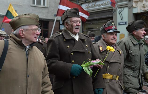 Des hommes habillés en uniformes lettons d'avant la deuxième Guerre mondiale et des vétérans de la Légion lettone, qui a combattu aux côtés de la Waffen SS, le 16 mars 2014 à Riga [Ilmars Znotins / AFP]