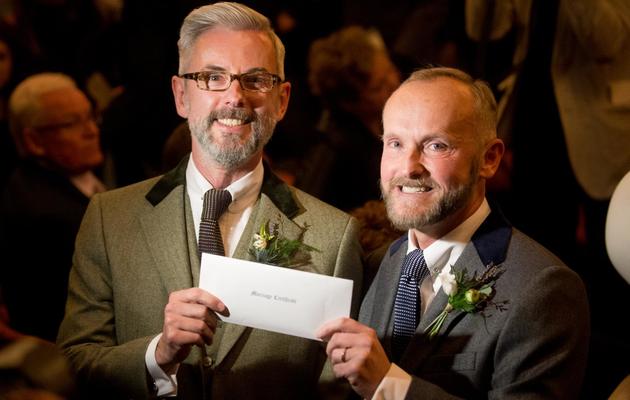Andrew Wale et Neil Allard montrent leur certificat de mariage à l'issue de la cérémonie le 29 mars 2014 à Brighton [Leon Neal / AFP]