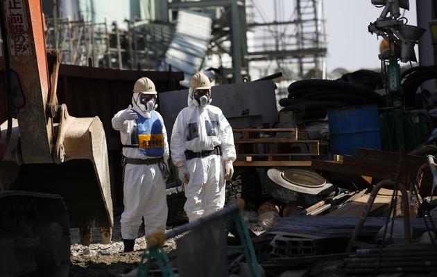 Des employés vêtus d'équipements de protection près du réacteur 4 de la centrale nucléaire de Fukushima Daiichi, le 6 mars 2013 [Issei Kato / POOL/AFP/Archives]