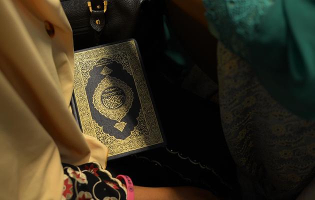 Une concurrente au titre de "Miss musulmane" porte un exemplaire du Coran, le 18 septembre 2013 à Jakarta [Adek Berry / AFP]