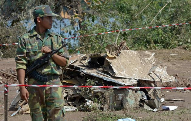 Un soldat laotien devant les débris de l'ATR-72 qui s'est abîmé dans le Mékong, le 19 octobre 2013 à Paksé [Pornchai Kitiwongsakul / AFP/Archives]