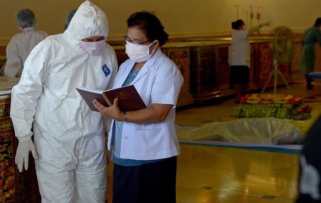 Des médecins légistes thaïs et laotiens établissent la liste des victimes d'un accident d'avion, le 19 octobre 2013 à Paksé, au Laos [Pornchai Kittiwongsakul / AFP]