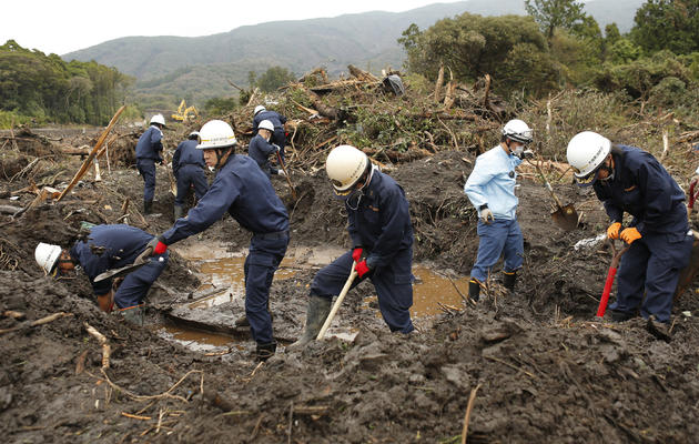 Des équipes de pompiers continuent à chercher de victimes d'un glissement de terrain, le 21 octobre 2013 sur l'île d'Oshima, au Japon [JijiPress / JijiPress/AFP]