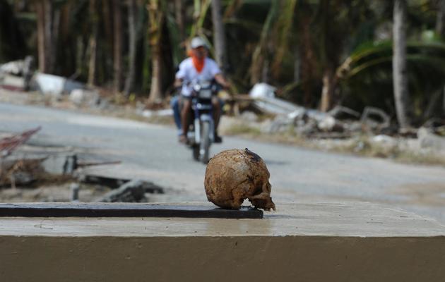 Un crâne humain sur le bord de la route après la destruction des tombes du cimetière de Hernani par le typhon Haiyan, le 18 novembre 2013 aux Philippines [Tel Aljibe / AFP]