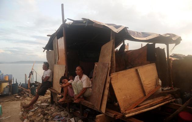 Des survivants du typhon Haiyan dans leur maison détruite à Tacloban, aux Philippines, le 26 novembre 2013 [Noel Celis / AFP]