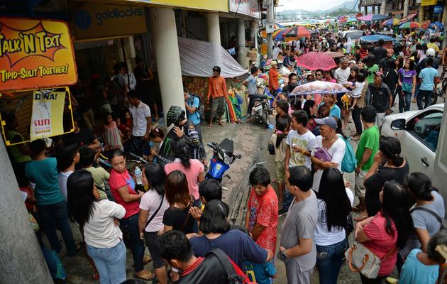 Des centaines d'habitants font la queue pour acheter des gâteaux de Noël à Tacloban le 24 décembre 2013  [Ted Aljibe / AFP]