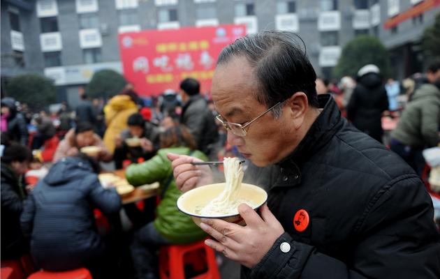 Un homme mange un bol de nouilles traditionnelles, offert aux Chinois à l'occasion du 120e anniversaire de la naissance de Mao Tsa-toung le 26 décembre 2013 à Shaoshan, sa ville natale [Wang Zhao / AFP]