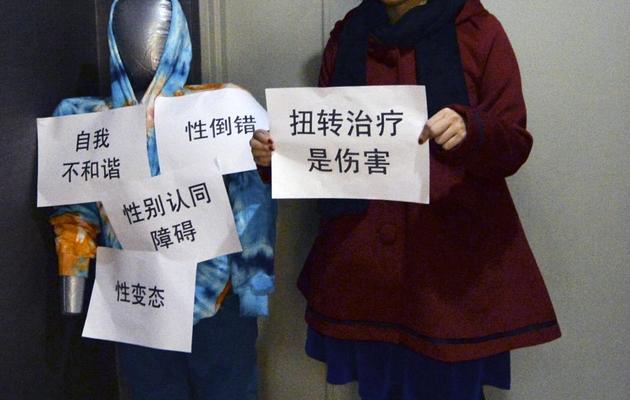 Une militante liée au Centre LGBT (Lesbiennes, Gay, Bissexuels et Transsexuels) de Pékin proteste avec un mannequin devant une clinique de Pékin proposant de "corriger" l'orientation sexuelle, le 10 décembre 2010 [Mark Ralston / AFP/Archives]